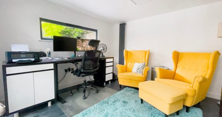 Inside garden office with bright yellow chairs and office furniture