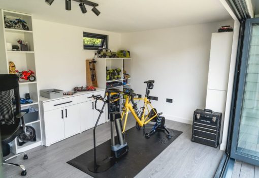 Yellow road bike on smart trainer inside garden gym